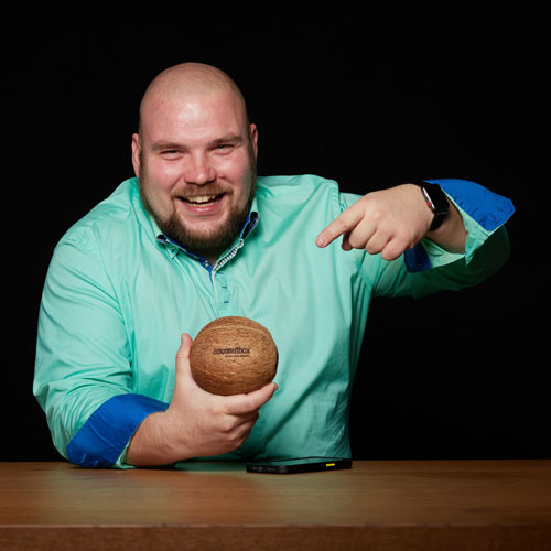 Mitarbeiter von coconutbox hält eine Kokosnuss mit Logo in der Hand